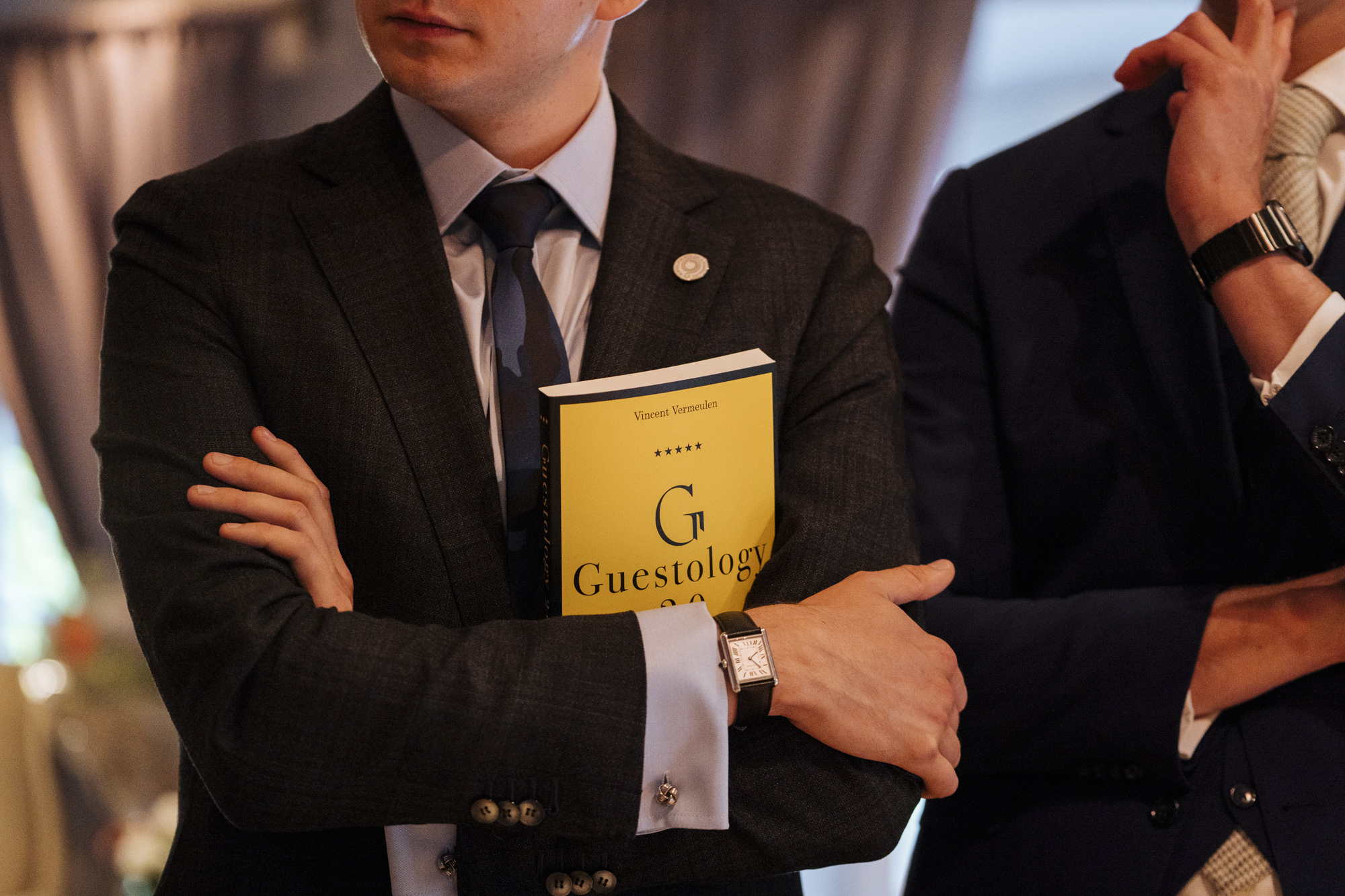 A guest holding Guestology 2.0 at the book launch, 2022